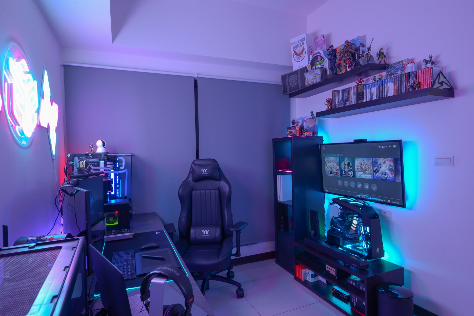 A modern gaming setup featuring a sleek gaming chair, dual monitors on a desk, and LED lighting. A gaming console and various decorations are displayed on shelves, creating an organized and vibrant gaming environment.