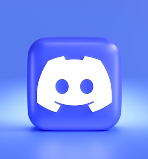 A three-dimensional blue cube featuring a white, stylized gaming controller symbol associated with a popular communication platform, set against a gradient blue background.